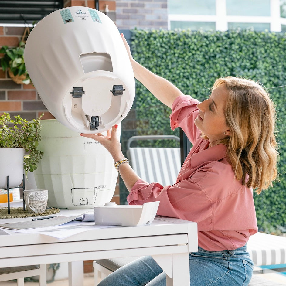 A woman is holding a PerkyPod large white plant pot up to show the view from underneath. There are three wheels underneath, including an Omni-directional castor wheel and two rollers to ensure excellent manoeurability for your plants. These castors are optional, removable and discrete so they don’t detract from the pot aesthetics.